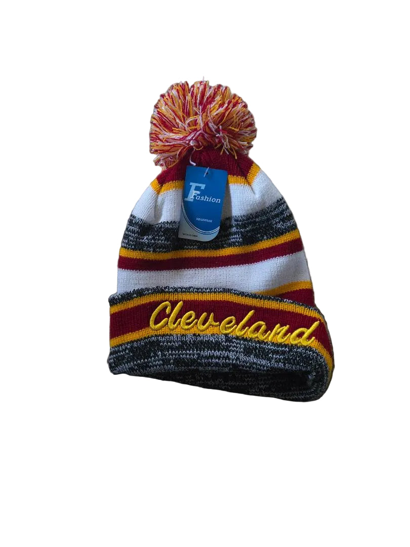 Colorful beanie with pom-pom and 'Cleveland' text on a brown surface

