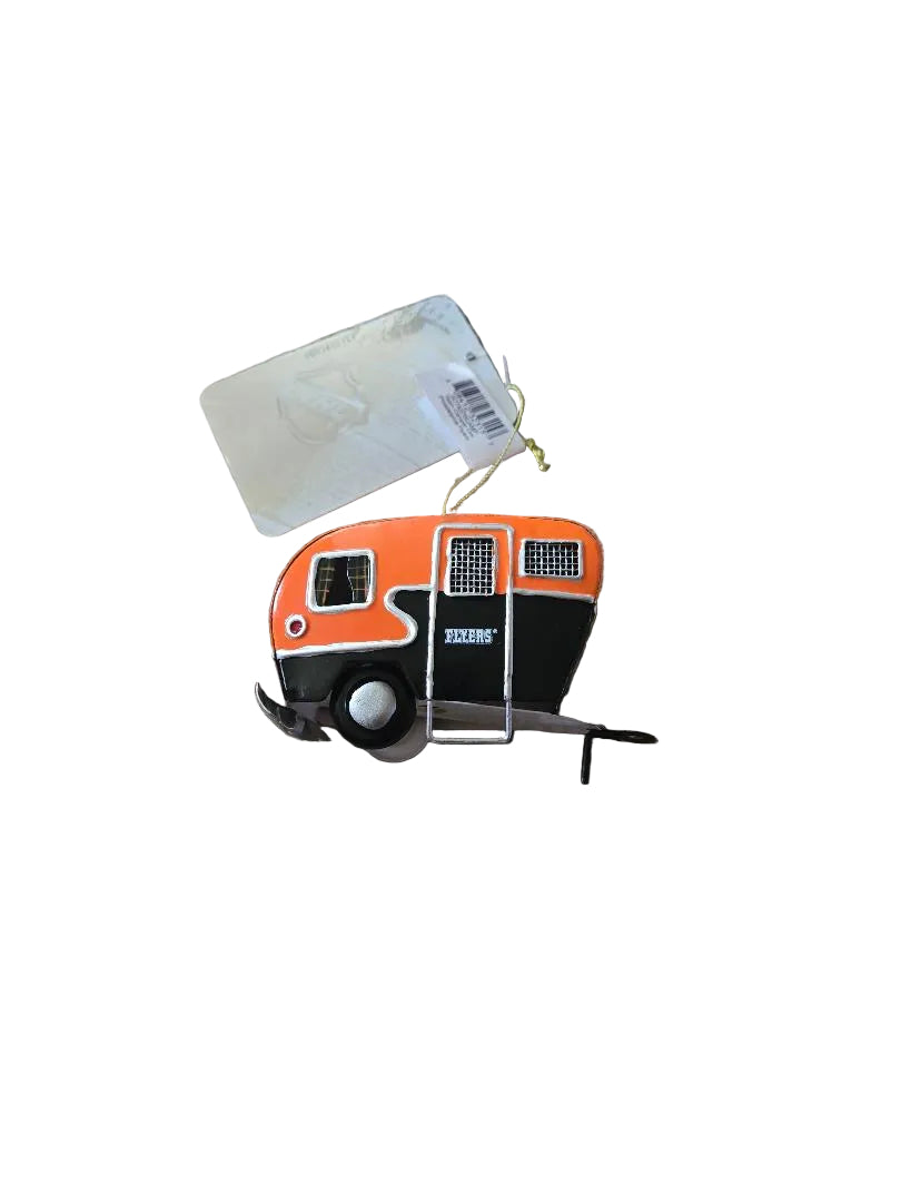 Small toy camper on a beige carpet with a tag attached

